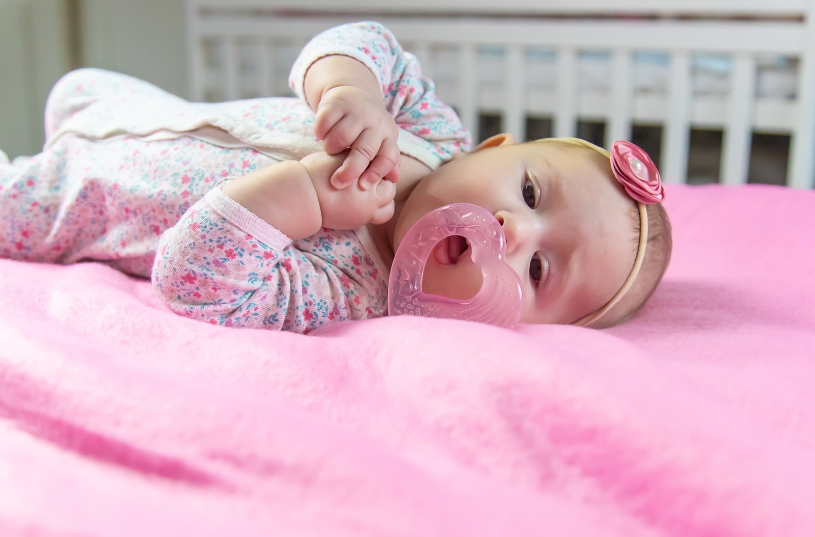 Baby is gnawing on a teether. Selective focus.